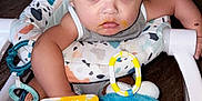 Kyire is registered to the contest to win money with this photo: baby, baby_food, child, clothing, colorful, door, expression, face, feeding, floor, food, hand, high_chair, indoor, infant, messy, person, seat, spoon, toy
