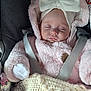 baby, sleeping, car_seat, pink_jacket, white_bow, headband, blanket, cozy, infant, child, clothing, safety_belt, cute, peaceful, closeup, soft_texture, warm, resting, newborn, portrait