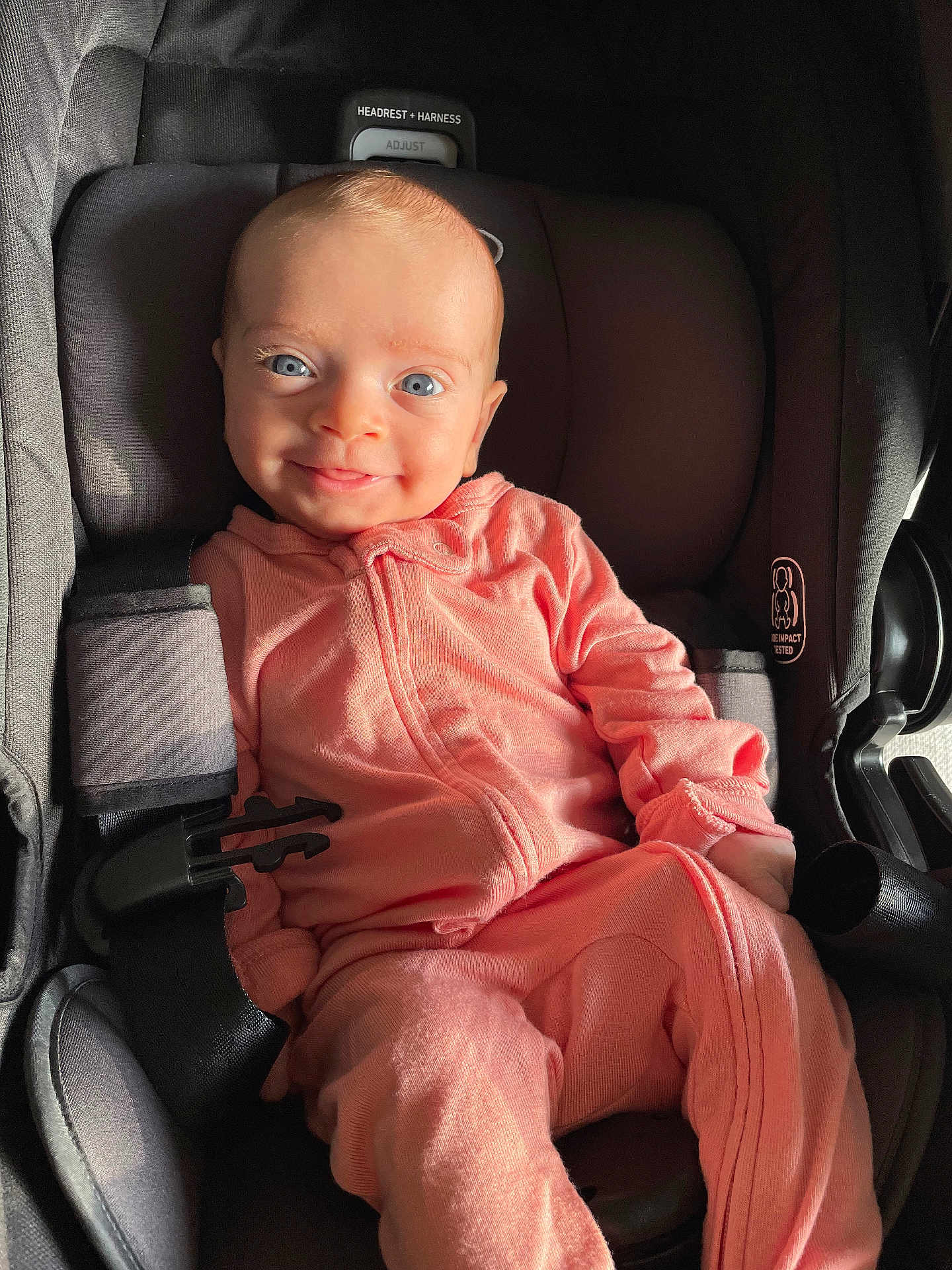 Olivia joined the competition — help win amazing prizes! baby, infant, car_seat, pink_clothing, smile, happy, child, seatbelt, blue_eyes, face, portrait, cute, young_child, clothing, sitting, indoor, headrest, harness, closeup, person