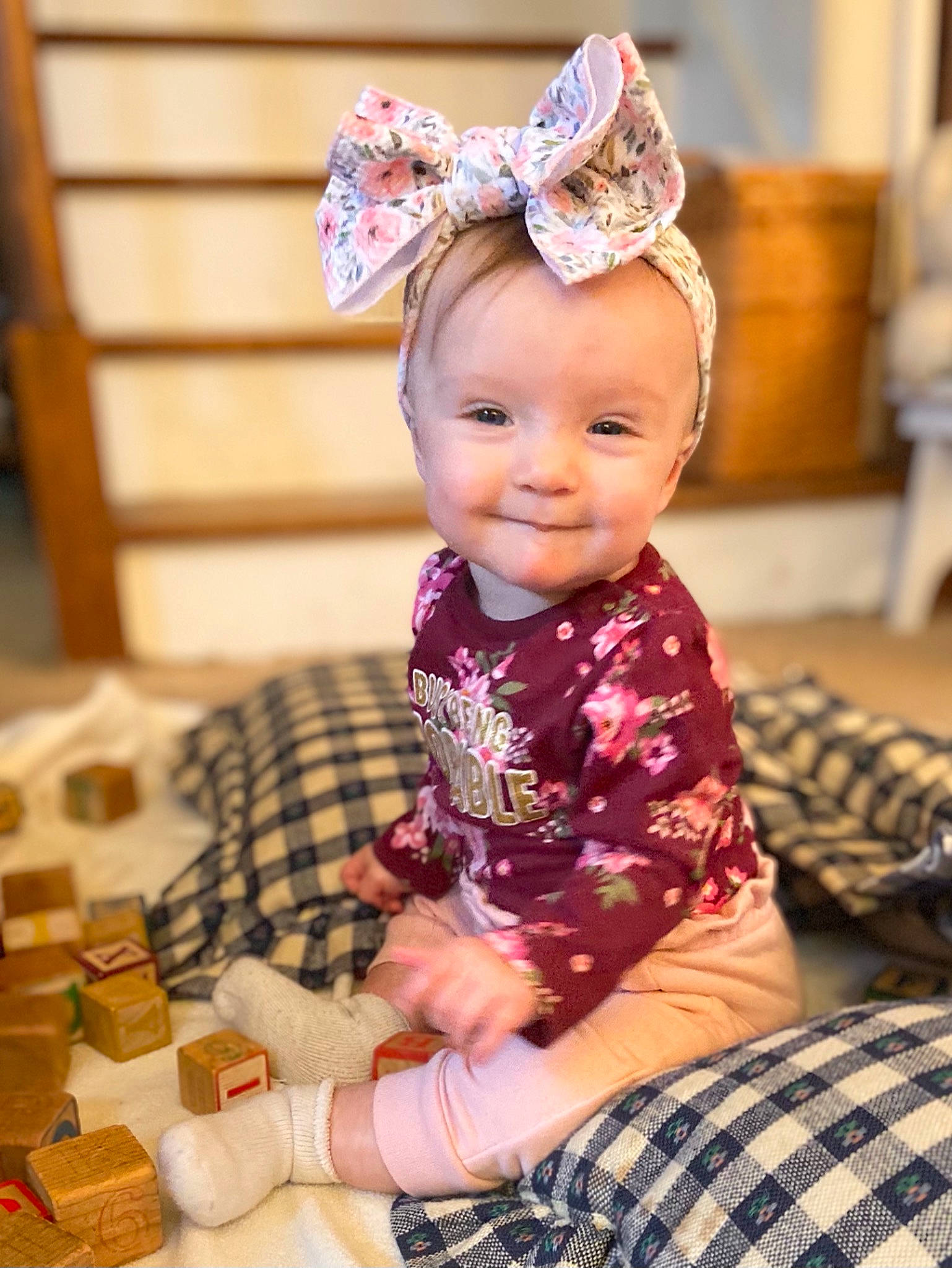 Juliet is registered to the contest to win money with this photo: baby, baby_toddler_clothing, child, fun, happy, headband, headpiece, human, pattern, people, person, pink, plaid, purple, sitting, skin, sleeve, smile, tartan, textile