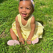 Kailani is registered to the contest to win money with this photo: toddler, child, smiling, yellow_dress, headband, grass, outdoor, sunlight, happy, baby, nature, sitting, greenery, cute, portrait, person, daylight, feet, shoes, bracelet
