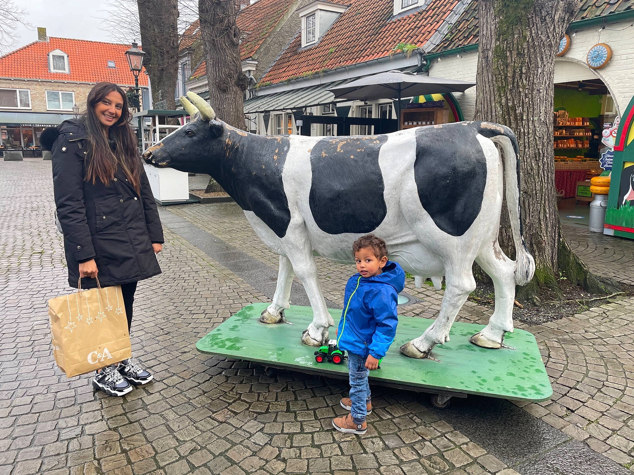Djibril participe au concours pour gagner de l'argent avec cette photo : bag, boot, bovine, building, dairy_cow, event, fun, green, human_settlement, joy, leisure, livestock, luggage_and_bags, person, shoe, snout, temple, toddler, tourism, tree