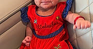 Lizbeth is registered to the contest to win money with this photo: baby, bow, child, clothing, colorful, comfortable, cute, embroidery, fist, happy, headband, indoor, infant, leather_chair, person, polka_dot, portrait, red_dress, sitting, smile