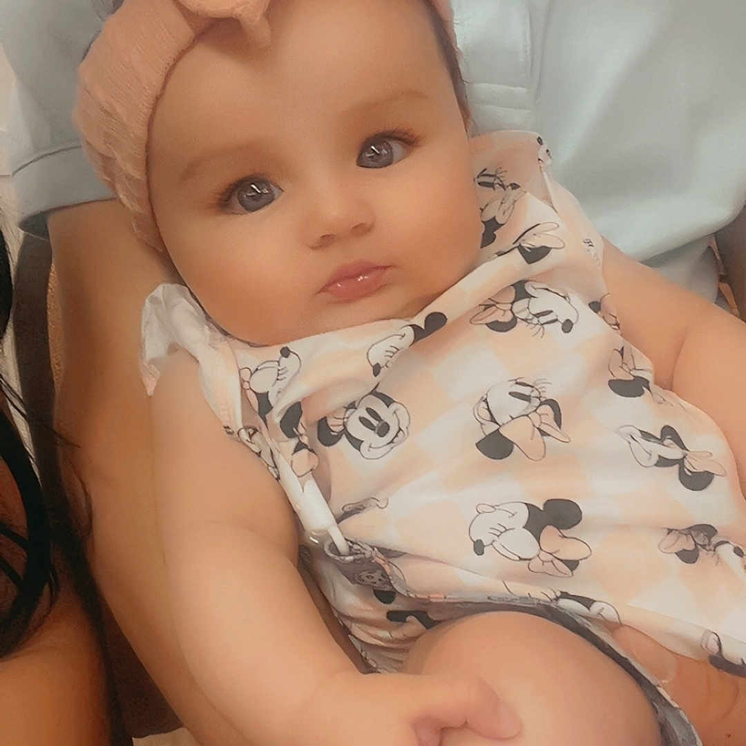 Zellyana joined the competition — help win amazing prizes! arm, baby, bow, child, clothing, cute, expression, face, hand, headband, holding, indoor, infant, leg, mickey_mouse, outfit, person, portrait, seated, skin