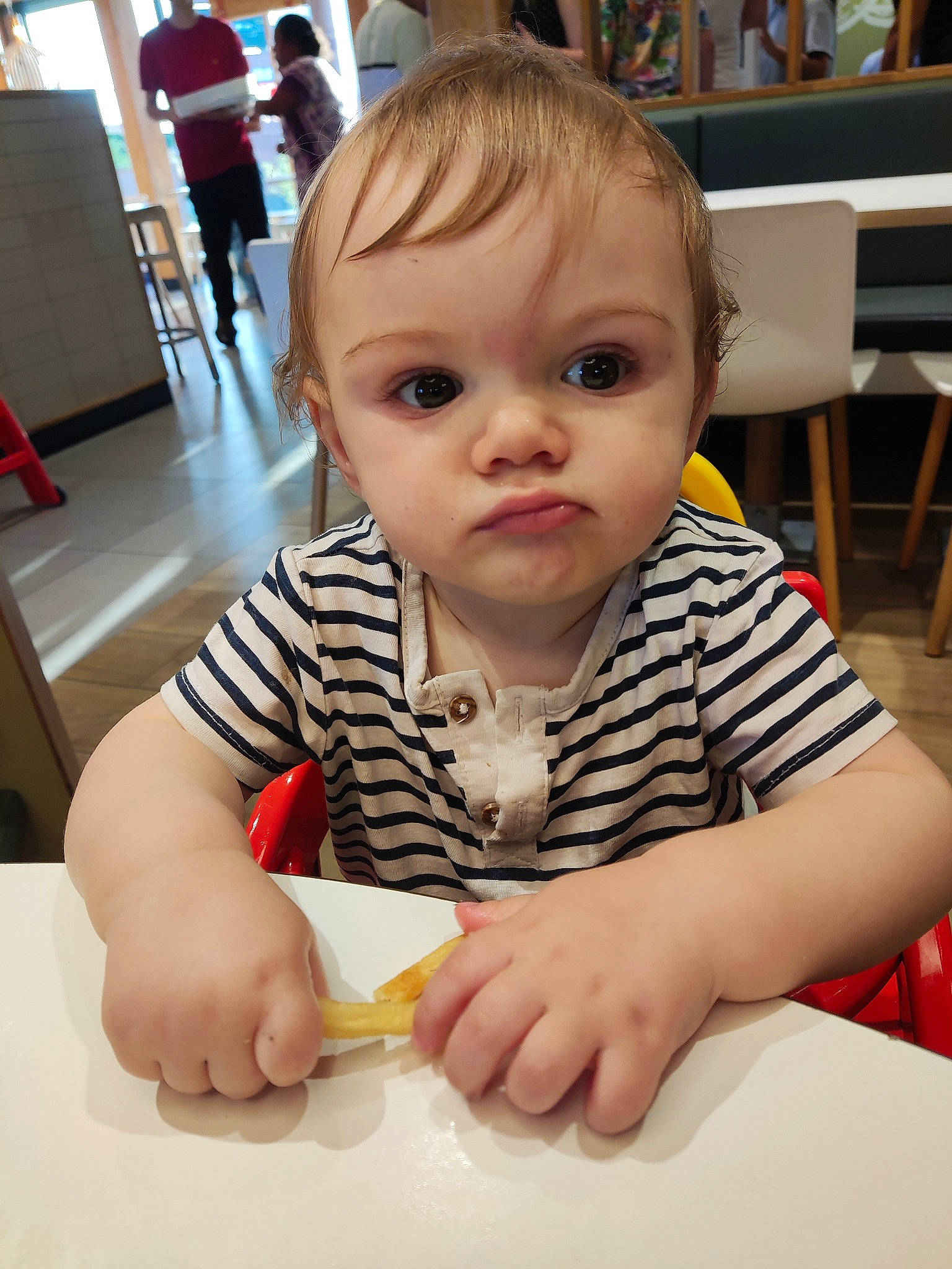 Julio participe au concours pour gagner de l'argent avec cette photo : baby, baby_toddler_clothing, breakfast, chair, cheek, child, comfort_food, cutlery, desk, eating, event, flooring, fun, person, room, sitting, table, tableware, toddler, under_exposed
