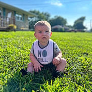 Bryson joined the competition — help win amazing prizes! baby, child, grass, outdoor, blue_sky, bib, sitting, greenery, sunlight, house, lawn, portrait, infant, clothing, expression, nature, daylight, young_child, curious, casual