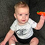 Bryson is registered to the contest to win money with this photo: baby, child, sitting, couch, toy, white_socks, shorts, tshirt, indoor, face, person, cute, happy, infant, furniture, home, playing, looking, expression, skin