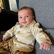 Maïron a rejoint le concours — aidez-le/la à gagner de superbes lots ! baby, child, infant, smile, shirt, pants, striped_pants, couch, furniture, indoor, happy, face, person, seated, button_up_shirt, cozy, home, reaching_hand, cute, portrait