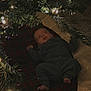 Liam Hughes joined the competition — help win amazing prizes! baby, infant, christmas_tree, blanket, plaid, lights, holiday, festive, indoors, carpet, ornaments, greenery, cute, child, cozy, soft_lighting, decorations, smiling, relaxing, winter