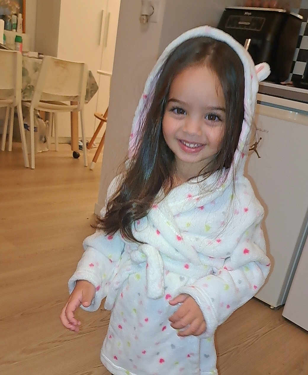 Elena a rejoint le concours — aidez-le/la à gagner de superbes lots ! child, girl, smiling, robe, hood, indoor, kitchen, wooden_floor, furniture, cabinet, appliance, long_hair, happy, person, home, cozy, cute, young, polka_dot, standing