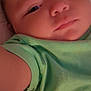 Blake is registered to the contest to win money with this photo: baby, face, closeup, infant, child, green_shirt, sleepy, person, portrait, skin, expression, cute, young, indoor, soft_light, blanket, cozy, head, arm, toddler