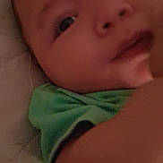 Blake joined the competition — help win amazing prizes! baby, close_up, face, green_shirt, infant, child, quilted_surface, skin, eyes, nose, mouth, arm, indoor, soft_lighting, portrait, young_child, expression, relaxed, curious, blurred