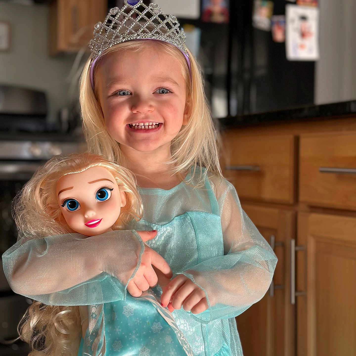 Lyla is registered to the contest to win money with this photo: accessories, bodypart, child, clothing, costume, doll, dress, face, female, finger, formalwear, girl, head, jewelry, person, photography, portrait, tiara, toy, wood