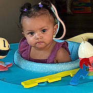 Eliana joined the competition — help win amazing prizes! baby, child, indoor, walker, toy, purple_hair_ties, face, person, curious, expression, blue, yellow, red, plastic, dog, shadow, furniture, head, clothing, cute