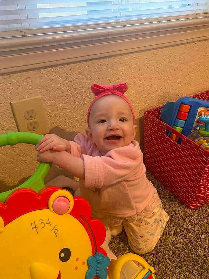 Elianna is registered to the contest to win money with this photo: baby, baby_playing_with_toys, baby_products, baby_toddler_clothing, baby_toys, child, face, facial_expression, fun, happy, leisure, person, play, product, room, smile, toddler, toy, window, window_blind