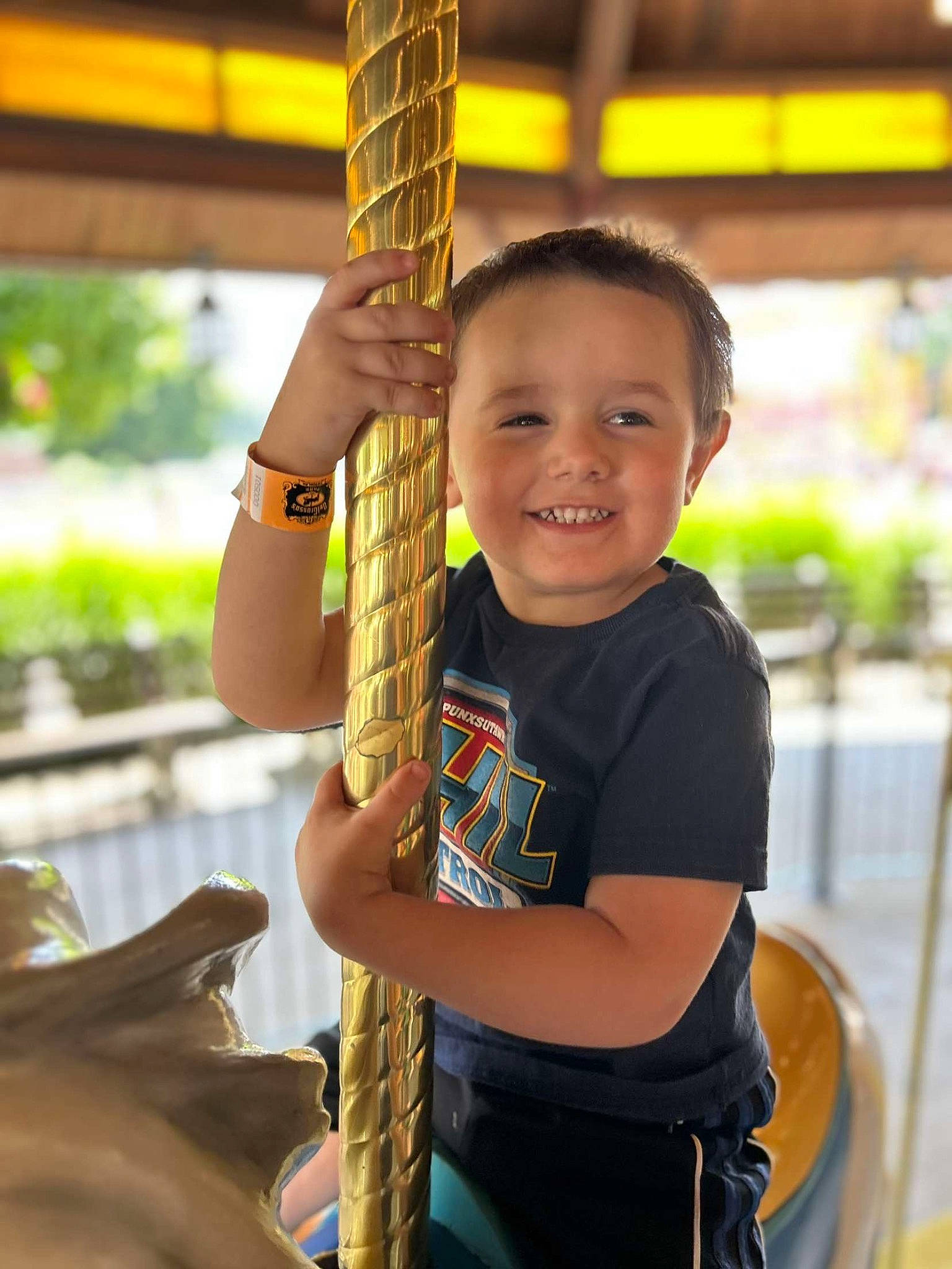 Christopher is registered to the contest to win money with this photo: child, chin, city, elbow, fun, gesture, hand, happy, joy, leisure, neck, outdoor_play_equipment, person, recreation, skin, smile, swing, temple, thumb, toddler