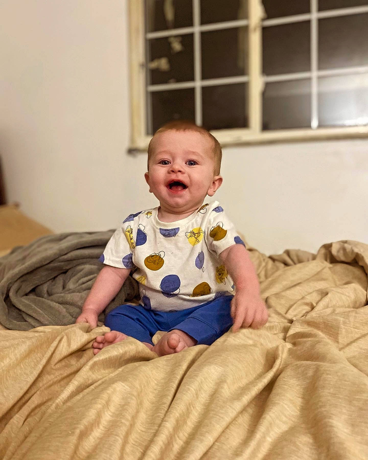 Mack joined the competition — help win amazing prizes! baby, baby_toddler_clothing, cheek, child, comfort, face, facial_expression, flash_photography, flooring, fun, happy, linens, pattern, person, sitting, skin, sleeve, smile, t_shirt, toddler