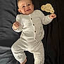 7_months, baby, blanket, child, cozy, cute, face, feet, hands, happy, indoors, infant, lying_down, milestone, person, portrait, smiling, soft_texture, white_clothing, wooden_sign