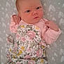 Aiyana is registered to the contest to win money with this photo: baby, infant, blanket, floral, pattern, face, expression, pink, yellow, green, lying_down, hands, clothing, cute, newborn, person, bed, sheet, closeup, portrait