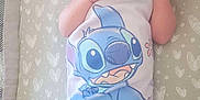 Aiyana is registered to the contest to win money with this photo: baby, cartoon_character, child, cute, fabric, hands_near_face, heart_pattern, indoors, infant, lying_down, mattress, newborn, onesie, pacifier, peaceful, sleeping_area, sleepwear, small, soft_lighting, stitch