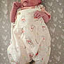 baby, newborn, infant, overalls, clothing, cartoon, pattern, bear, blanket, heart_pattern, cute, lying_down, small_hands, footwear, indoors, soft_lighting, portrait, child, expression, peaceful