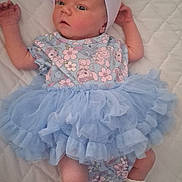 Aiyana joined the competition — help win amazing prizes! baby, infant, blue_dress, headband, bow, socks, lying_down, quilted_blanket, cute, clothing, newborn, child, portrait, soft_fabric, patterned_clothes, small_feet, baby_girl, indoors, sleepwear, toddler