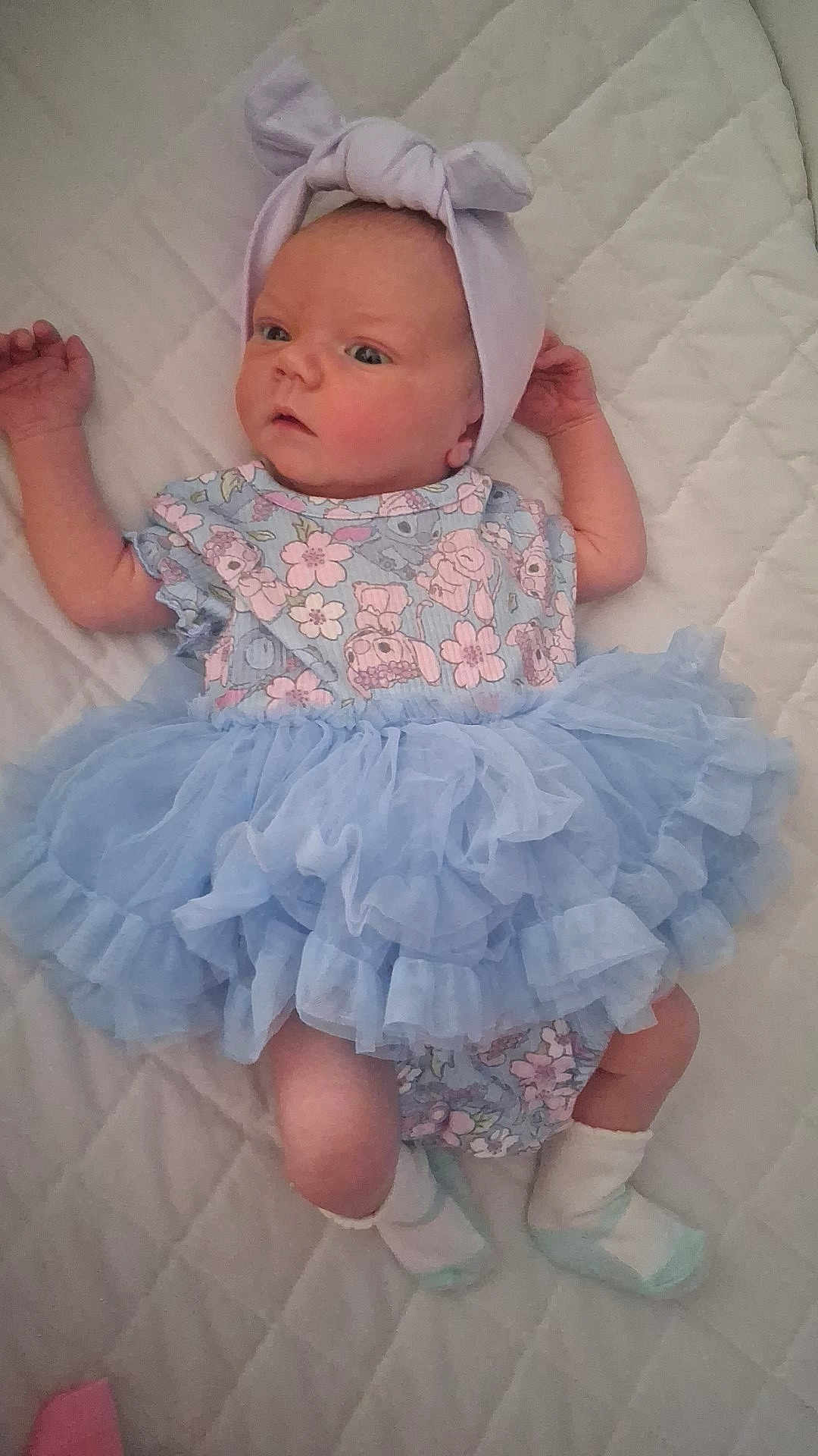 Aiyana joined the competition — help win amazing prizes! baby, infant, blue_dress, headband, bow, socks, lying_down, quilted_blanket, cute, clothing, newborn, child, portrait, soft_fabric, patterned_clothes, small_feet, baby_girl, indoors, sleepwear, toddler