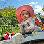 baby, child, pink_hat, outdoor, toy, bottle, blanket, nature, sky, cloud, greenery, playtime, cute, infant, sunhat, grass, daylight, garden, portrait, play
