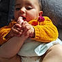 baby, infant, foot, hand, orange_sweater, cushion, gray, cute, lying_down, skin, child, chewing, comfort, indoor, cozy, plush, relaxed, baby_clothes, small_hands, chubby_legs
