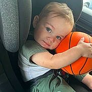 Jay Oliver is registered to the contest to win money with this photo: child, toddler, car_seat, basketball, blue_eyes, smile, baby_bottle, green_clothing, seatbelt, car_interior, portrait, cute, infant, seat, vehicle, hugging, short_hair, sippy_cup, happy, closeup