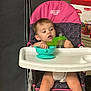 Jay Oliver is registered to the contest to win money with this photo: toddler, child, high_chair, sippy_cup, bowl, indoor, curious, pink, navy, pattern, diaper, face, arm, legs, floor, cardboard_box, furniture, baby, seat, person
