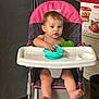 toddler, child, high_chair, indoor, baby, feeding, bowl, plastic_bowl, pink, black, patterned, face, expression, feet, hands, furniture, floor, cardboard_box, container, person