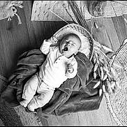 Thélyo a rejoint le concours — aidez-le/la à gagner de superbes lots ! baby, infant, yawning, blanket, hat, wooden_floor, rug, dried_plants, cozy, indoor, sleepy, clothing, small_person, resting, laying_down, monochrome, black_and_white, soft_texture, peaceful, portrait