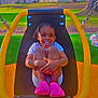 child, smiling, swing, playground, outdoor, grass, trees, braided_hair, pink_shoes, sunny, happy, seat, park, daytime, fence, casual_clothing, nature, play, person, fun