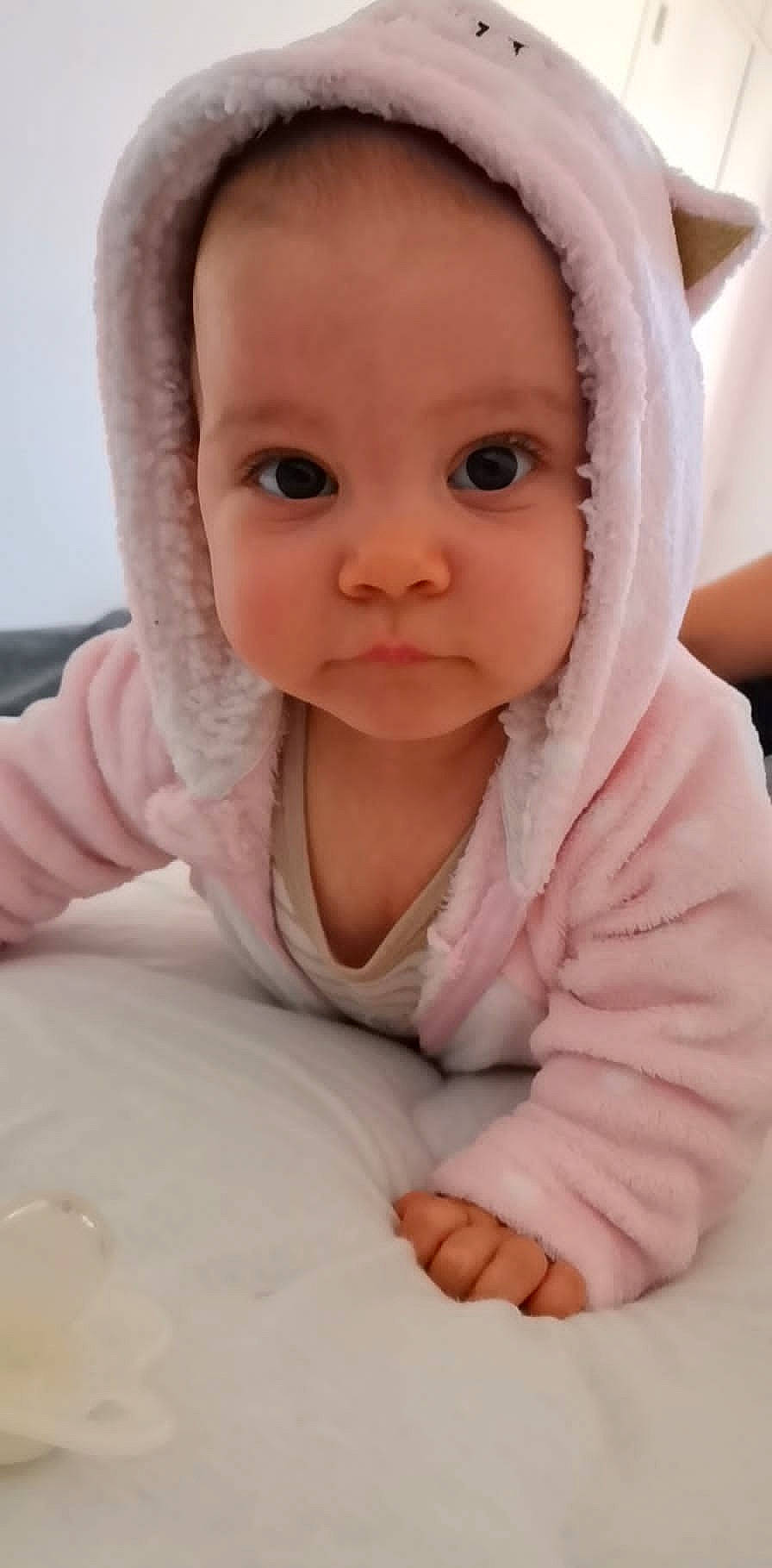 Tessa participe au concours pour gagner de l'argent avec cette photo : baby, baby_toddler_clothing, cheek, comfort, eyebrow, eyelash, finger, gesture, iris, lip, mouth, nail, neck, nose, outerwear, person, pink, skin, sleeve, thumb