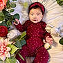 Karleen Renee joined the competition — help win amazing prizes! baby, infant, child, polka_dot, headband, maroon_clothing, flowers, artificial_flowers, green_leaves, white_bed, smiling, portrait, cute, lying_down, soft_lighting, closeup, face, hand, pink, red
