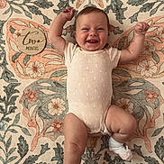 Charlotte joined the competition — help win amazing prizes! baby, smiling, onesie, white_socks, lying_down, floral_pattern, butterfly_design, wooden_plaque, two_months, milestone, happy, infant, cute, cheerful, arms_raised, blanket, floor, portrait, skin, head