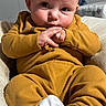 Echo is registered to the contest to win money with this photo: baby, blanket, child, clothing, cozy, curious, cute, expression, face, hands, indoor, infant, portrait, relaxed, sitting, soft_lighting, striped_blanket, white_socks, yellow_outfit, young