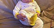 Echo joined the competition — help win amazing prizes! apparel, baby, child, clothing, comfort, couch, cute, face, footwear, giraffe_slippers, hat, home, indoor, infant, onesie, person, portrait, quilted_blanket, seated, soft_furniture
