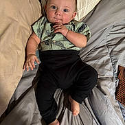 Echo is registered to the contest to win money with this photo: baby, infant, child, person, bed, blanket, shirt, pants, foot, hand, face, blue_eyes, curly_hair, skin, sleepwear, indoors, cozy, cute, lying_down, soft