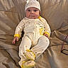 baby, bed, blanket, child, cozy, cute, face, footed_pajamas, glasses, hat, indoor, infant, pattern, person, portrait, quilt, sleepwear, smile, stars, yellow