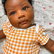 Jhené is registered to the contest to win money with this photo: adorable, baby, blanket, child, close_up, curly_hair, cute, eyes, face, heart_pattern, hello_kitty, infant, lying_down, onesie, orange_checkered, portrait, skin, smiling, soft_texture, young