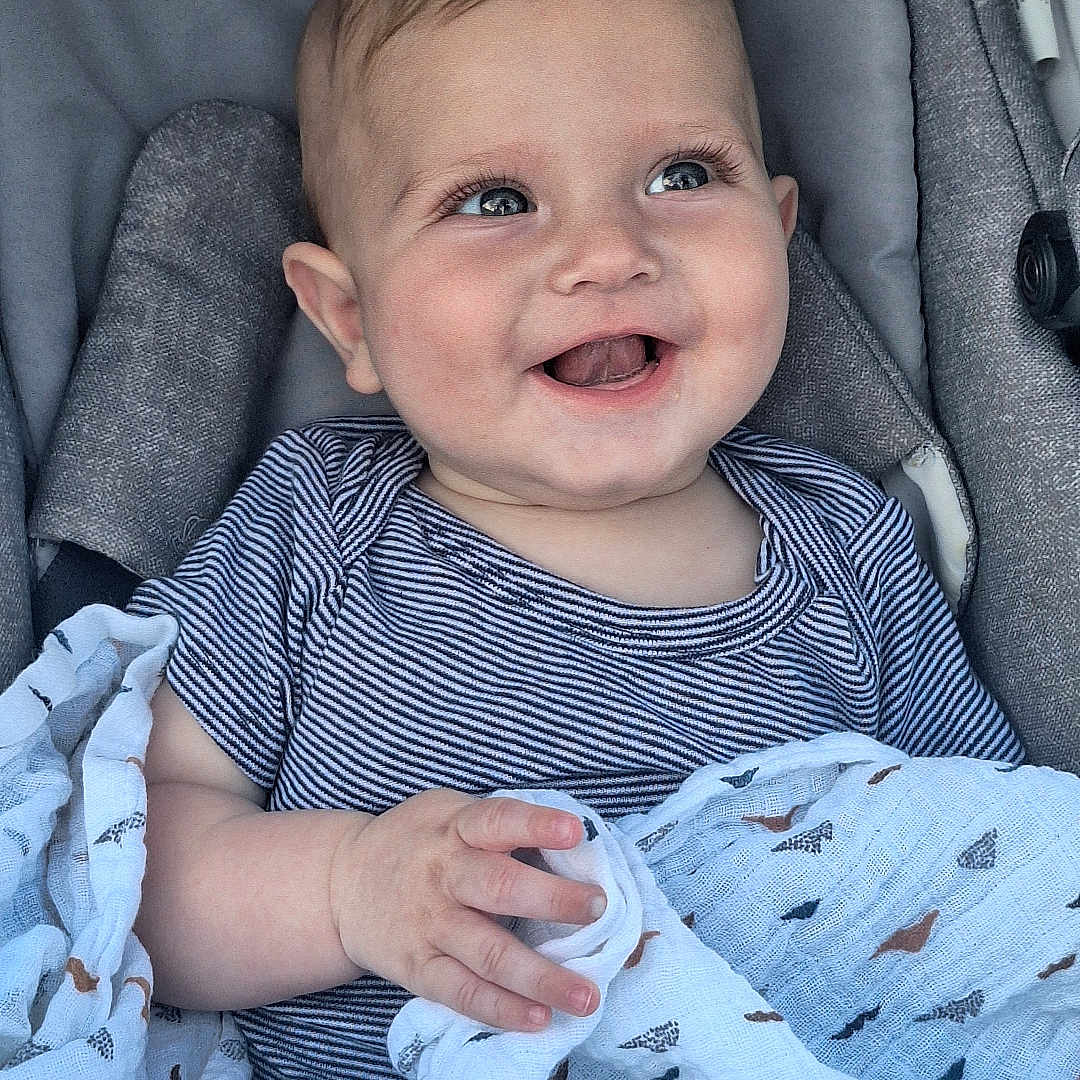 Noah a rejoint le concours — aidez-le/la à gagner de superbes lots ! baby, baby_seat, blanket, bébéconfort, child, closeup, clothing, comfort, cute, eyes, fabric, face, hand, happy, indoor, infant, portrait, smiling, striped_shirt, young_child