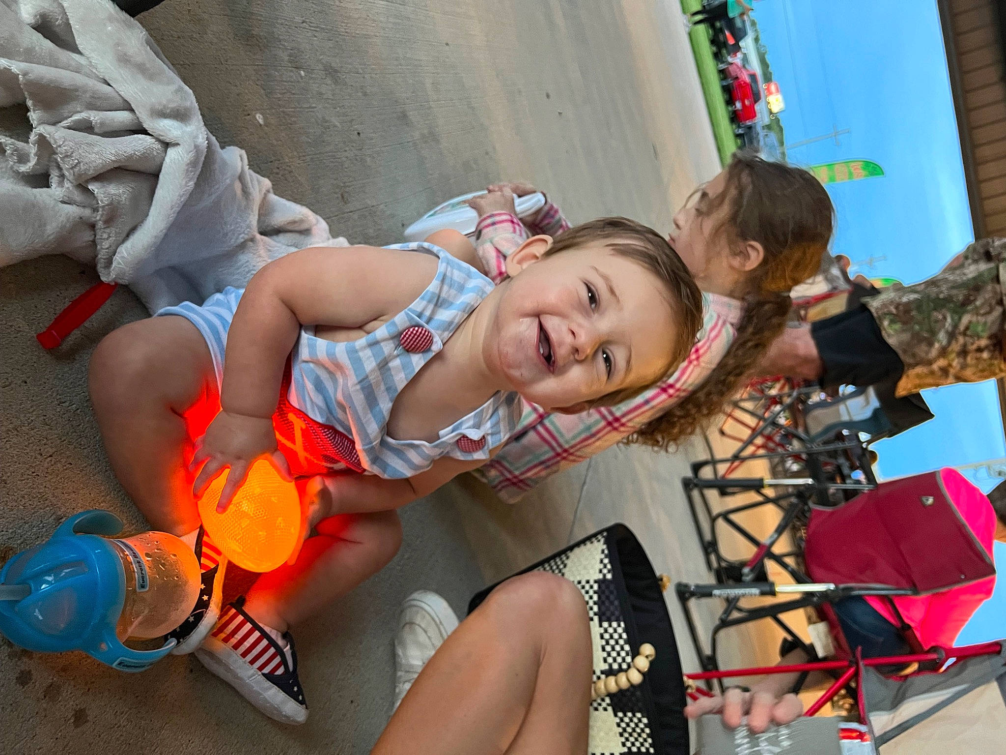 Everett is registered to the contest to win money with this photo: child, event, foot, fun, happy, human_leg, leisure, person, play, recreation, sandal, shorts, sitting, skin, smile, thigh, toddler, tourism, travel, vacation