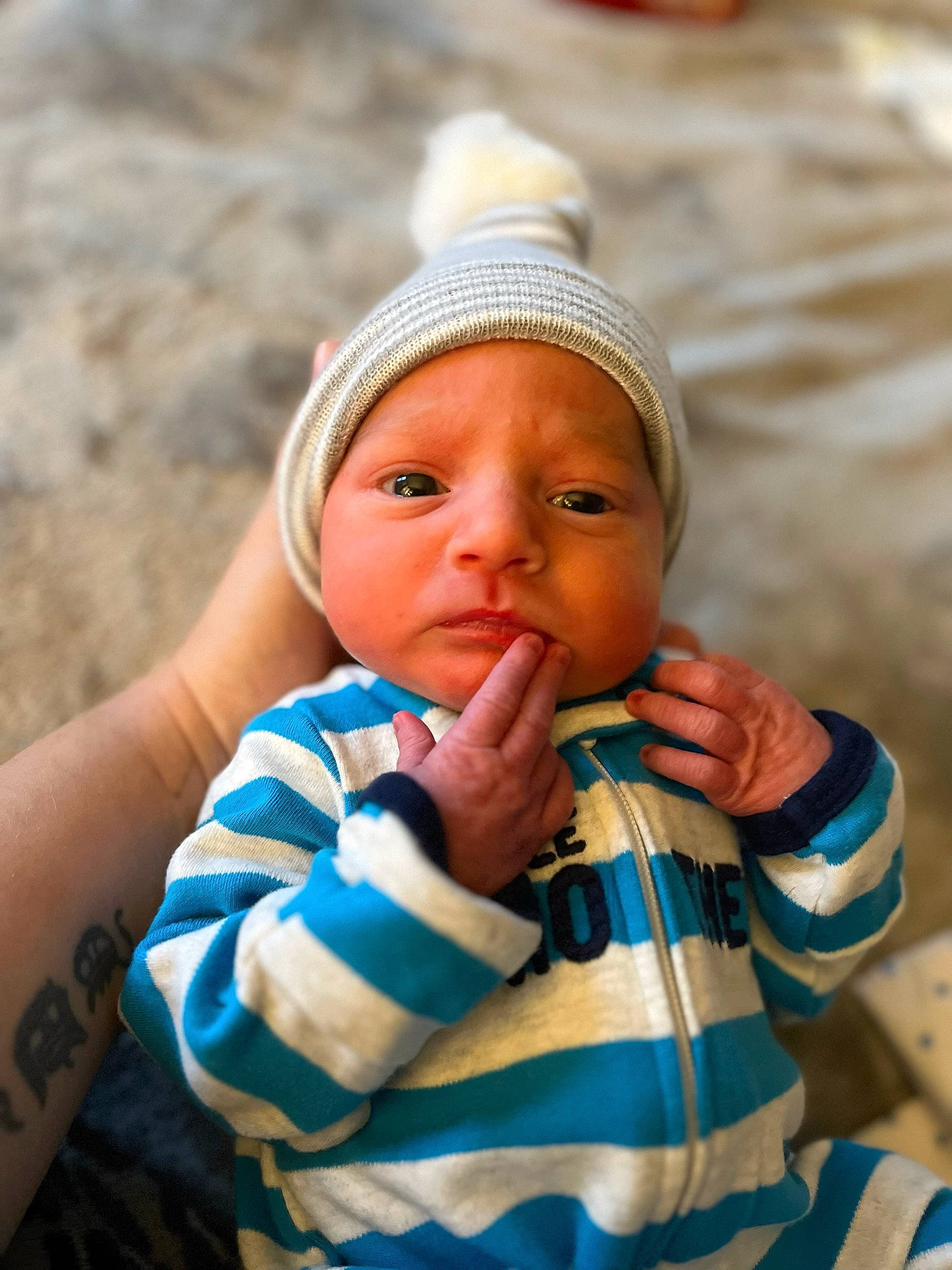 Messiah is registered to the contest to win money with this photo: arm, baby, baby_toddler_clothing, cap, cheek, chin, clothing, finger, grass, hand, happy, head, headwear, human_body, lip, mouth, nose, person, skin, toddler
