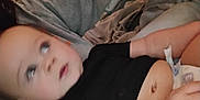 Kason is registered to the contest to win money with this photo: baby, infant, black_shirt, diaper, arm, person, skin, face, hand, lap, clothing, indoor, blur, casual, resting, child, human, adult, grey_sleeve, curious_expression