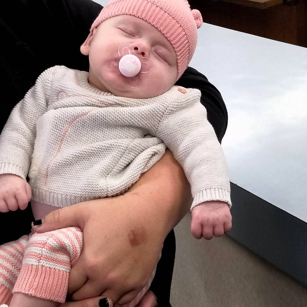 Bella is registered to the contest to win money with this photo: baby, baby_sleeping, baby_toddler_clothing, cheek, child, comfort, eye, finger, gesture, happy, head, headwear, human_body, knee, person, pink, skin, sleeve, stomach, thigh