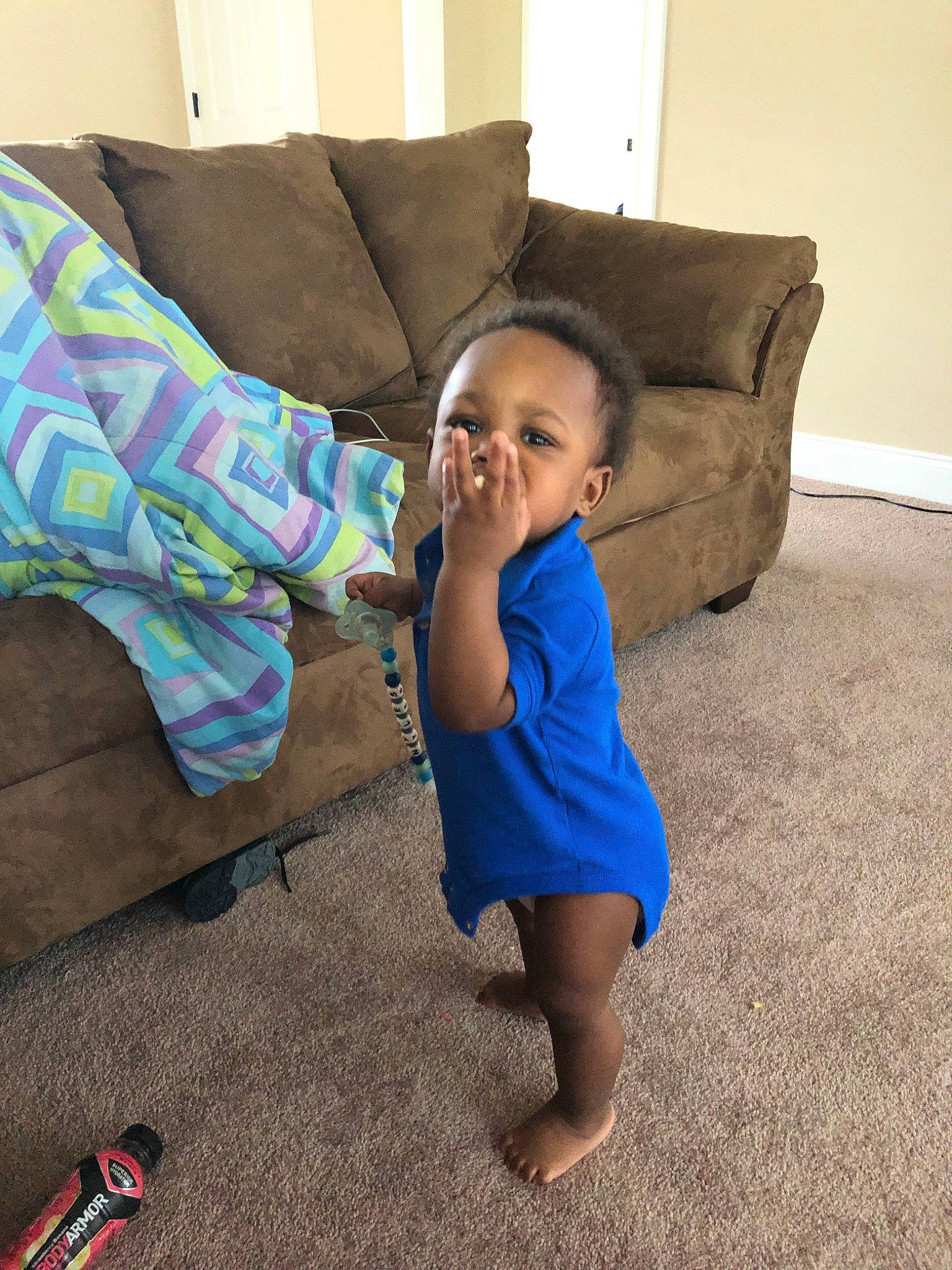 Kaeden is registered to the contest to win money with this photo: child, couch, finger, floor, flooring, fun, furniture, head, joint, leg, linens, living_room, person, play, room, shoe, shoulder, smile, textile, toddler