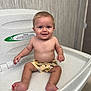 Tommy-Lee is registered to the contest to win money with this photo: baby, child, infant, smile, blue_eyes, shorts, sitting, changing_station, indoor, cute, happy, skin, person, young_child, light_skin, toes, arms, legs, head, expression