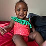 baby, child, toddler, smiling, swimsuit, sitting, bed, blanket, indoor, happy, face, person, cute, skin, foot, hand, bright_colors, young_child, portrait, cozy